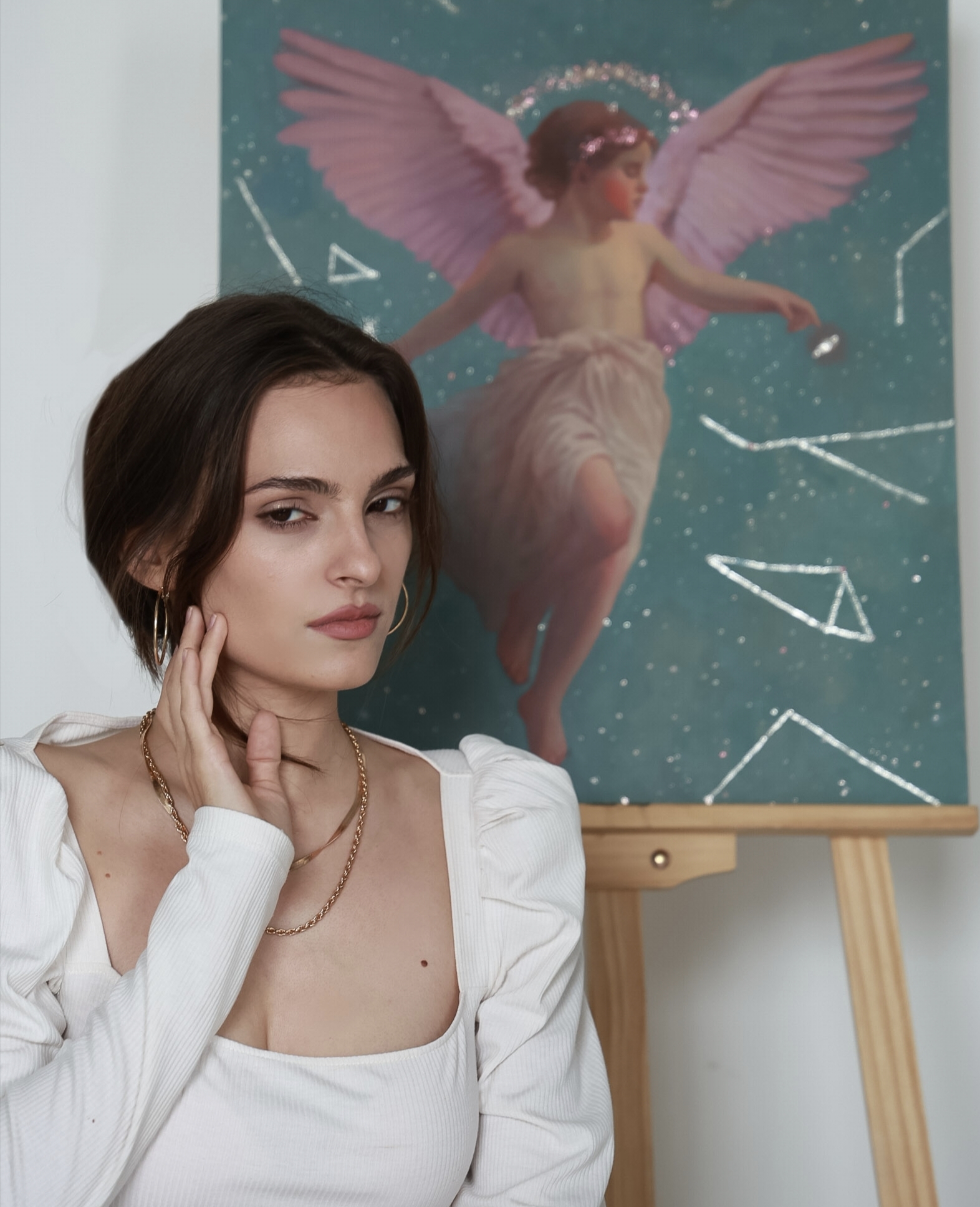 A close-up portrait of the artist in front of one of her paintings